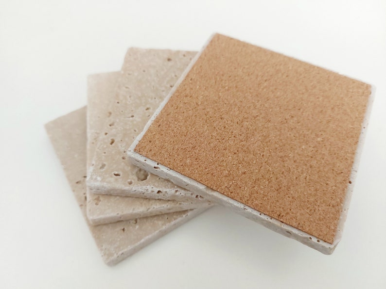 Op de afbeelding: Set van vier beige onderzetters met kurken achterkant. De onderzetters zijn gemaakt van een getextureerd materiaal en hebben een licht ruw oppervlak.
