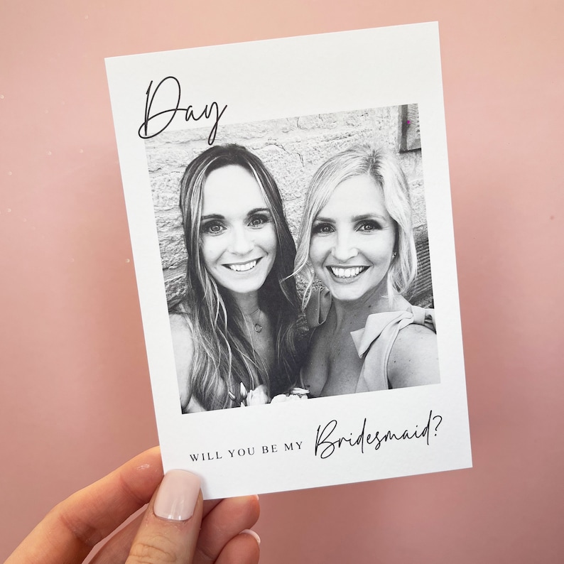 May include: A black and white photo of two women smiling. The text "Day" is at the top of the card and the text "Will you be my Bridesmaid?" is at the bottom.