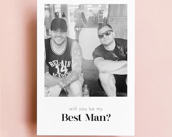 May include: Black and white photo of two men sitting outside. The man on the left is wearing a black tank top with the words "Bel-Air Academy" printed on it. The man on the right is wearing a black t-shirt. The text "will you be my Best Man?" is printed below the photo.