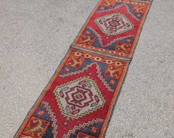 Op de afbeelding: Een lang, smal tapijt met een traditioneel Turks ontwerp. Het tapijt is gemaakt van wol en heeft een rood, blauw en oranje kleurenschema. Het tapijt is perfect om elke kamer een vleugje traditionele stijl te geven.
