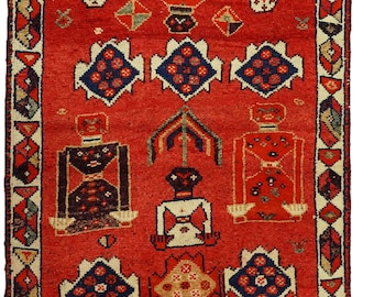 Könnte beinhalten: Ein roter Teppich mit einem geometrischen Muster, das stilisierte Figuren zeigt. Der Teppich hat einen cremefarbenen Rand mit einem geometrischen Muster.
