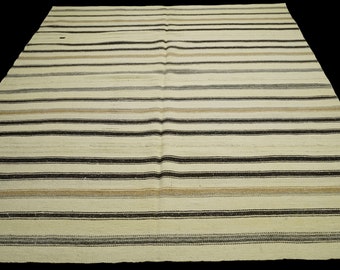 May include: A white and brown striped rug with a subtle sheen. The rug is woven with a simple pattern of horizontal stripes.