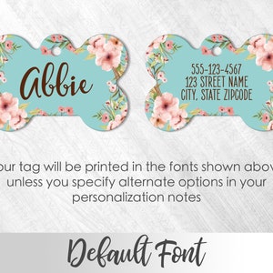 May include: A turquoise blue bone-shaped dog tag with a pink floral design. The tag is personalized with the name "Abbie" and includes space for a phone number, street address, city, state, and zip code.