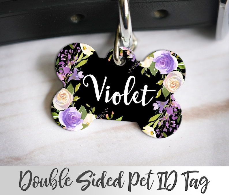 Puede incluir: Etiqueta de identificaci&oacute;n para mascotas de doble cara con forma de hueso, con un dise&ntilde;o floral en tonos morados, blancos y verdes. La etiqueta tiene el nombre "Violet" impreso en blanco sobre un fondo negro.