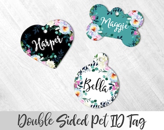 May include: Three double-sided pet ID tags with floral designs. The tags are shaped like a heart, a bone, and a circle. The heart tag is black with white text that says "Harper". The bone tag is teal with white text that says "Maggie". The circle tag is white with black text that says "Bella".