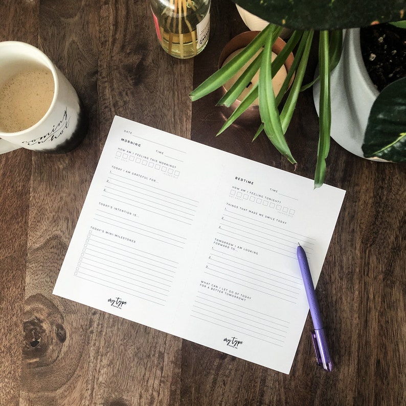 May include: A printable daily planner with sections for morning and bedtime routines. The planner includes prompts for gratitude, intentions, and things to look forward to. The planner is printed on white paper with black text.
