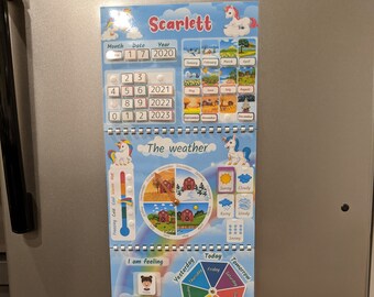 Puede incluir: Un calendario magnético colorido y una tabla de actividades para niños con temática de unicornio. El calendario incluye una sección de mes, fecha y año, una rueda del tiempo, una tabla de sentimientos, una rueda de los días de la semana y una sección para actividades y planes. La tabla está diseñada para ayudar a los niños a aprender sobre el tiempo, el clima, las emociones y las rutinas diarias.