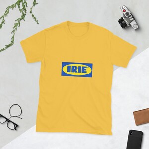 May include: A yellow t-shirt with a blue and yellow logo that says "IRIE". The shirt is a crew neck style and appears to be made of a soft material. The shirt is displayed on a flat surface.