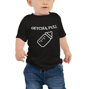 May include: A black short-sleeved baby onesie with white text that reads "GETCHA PULL" and a white outline of a baby bottle.