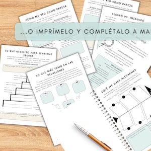 A collection of printed worksheets and a spiral-bound notebook with a pen on a wooden surface. The worksheets have text and diagrams in Spanish. The text "...O IMPRÍMELO Y COMPLÉTALO A MANO" is visible. The notebook is open to a page with a diagram.