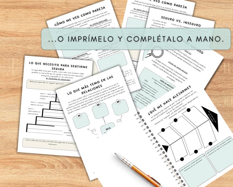 A collection of printed worksheets and a spiral-bound notebook with a pen on a wooden surface. The worksheets have text and diagrams in Spanish. The text "...O IMPRÍMELO Y COMPLÉTALO A MANO" is visible. The notebook is open to a page with a diagram.