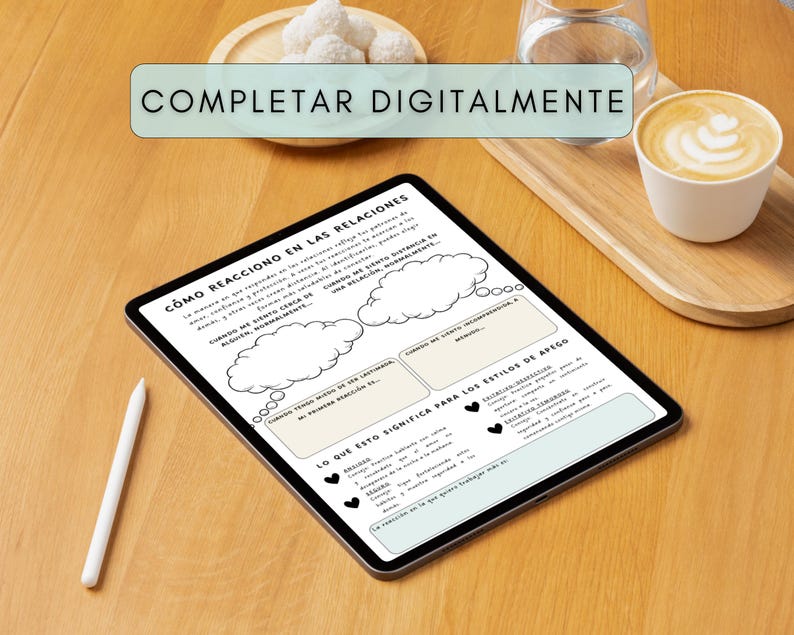 A digital tablet with a worksheet titled "How I React in Relationships" in Spanish. The tablet is on a wooden surface, with a stylus, a cup of coffee, and a small plate of white treats.