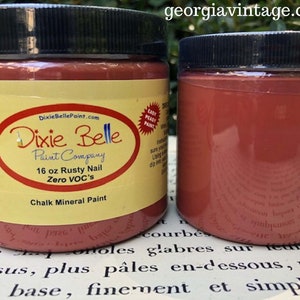 K&ouml;nnte beinhalten: Ein 473 ml Glas Dixie Belle Chalk Mineral Paint in der Farbe Rusty Nail. Die Farbe ist VOC-frei und einfach zu verwenden. Das Glas ist mit dem Dixie Belle Logo und der Website-Adresse beschriftet.