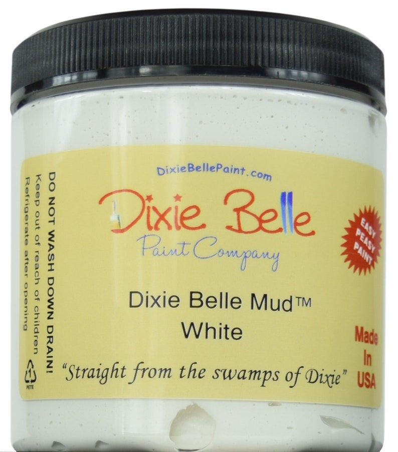 Op de afbeelding: Een witte pot Dixie Belle Mud verf, met het label "Dixie Belle Mud TM White" en "Straight from the swamps of Dixie". De pot is gemaakt in de VS en is gelabeld met "Easy Peasy Paint".