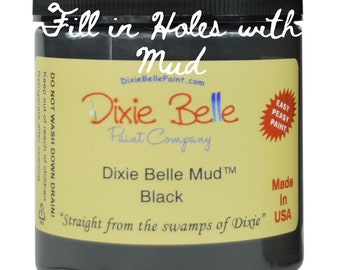 May include: A black jar of Dixie Belle Mud paint labeled "Fill in Holes with Mud". The jar is labeled "Dixie Belle Mud™ Black" and "Straight from the swamps of Dixie".