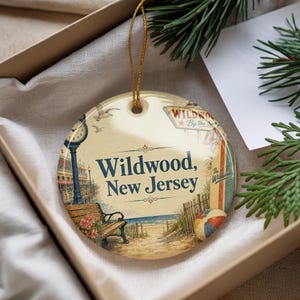 A decorative ornament in a box, featuring illustrations of a beach scene and the text "Wildwood, New Jersey".