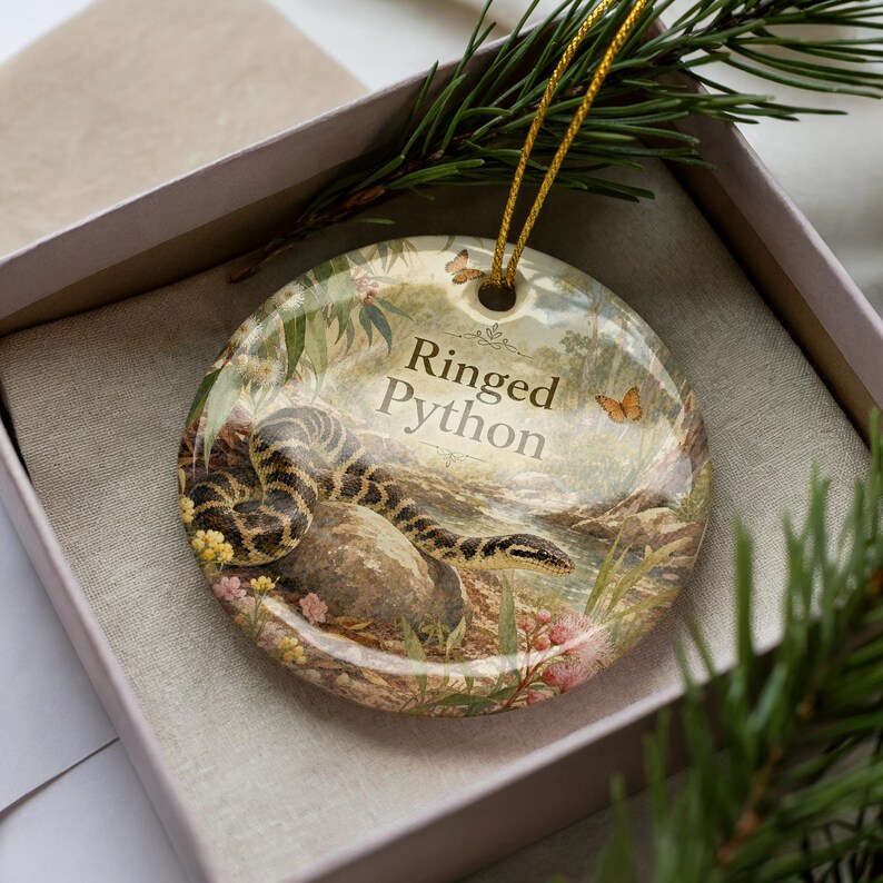 A decorative ornament in a box, featuring a snake and the text "Ringed Python".