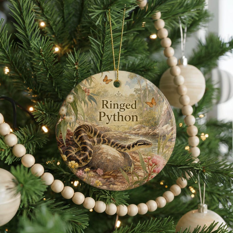 A round ornament on a Christmas tree featuring a snake and flowers, with the text "Ringed Python" displayed on it.