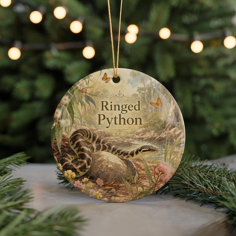 A round ornament featuring a snake and flowers, with the text "Ringed Python" displayed on it.