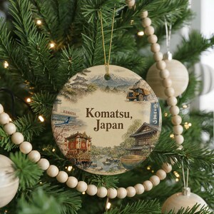 A round ornament hanging on a Christmas tree, featuring illustrations of various Japanese landmarks and scenery.