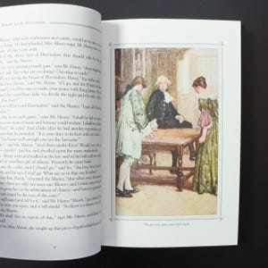 May include: An open book with a color illustration depicting a scene with three figures around a table. The figures are dressed in period clothing. The text on the page includes the title "ROBERT LOUIS STEVENSON". The illustration is framed with a decorative border.