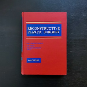 May include: A red hardcover book titled "Reconstructive Plastic Surgery" with the words "The Lower Extremity, The Trunk, The Genitourinary Tract" and "Converse" printed on the cover.