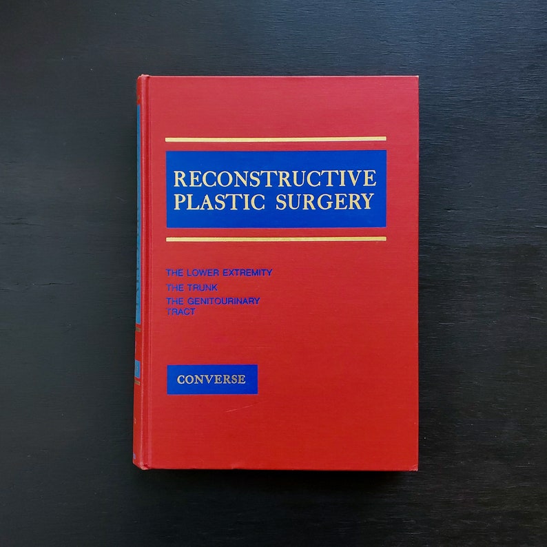 May include: A red hardcover book titled "Reconstructive Plastic Surgery" with the words "The Lower Extremity, The Trunk, The Genitourinary Tract" and "Converse" printed on the cover.