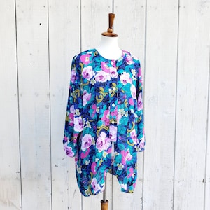 May include: A long-sleeved, blue, pink, and green floral print blouse with a button-up front.