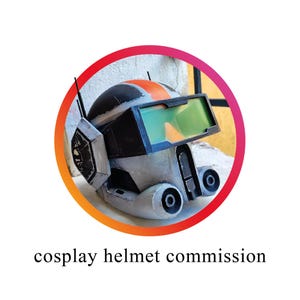 Puede incluir: Casco de cosplay detallado con una combinación de colores negro, gris y naranja. El casco presenta una visera con tonos verdes y naranjas, y dos pequeñas antenas. El texto "cosplay helmet commission" se muestra debajo.