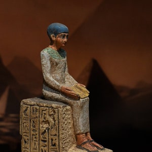 statue of Egyptian art Seated statue of Imhotep holding an open papyrus scroll stone made in egypt