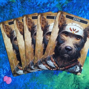 Pode incluir: Cinco cartas com fundo castanho e uma imagem de um cão com uma faixa branca na cabeça. O texto "DOG" está impresso no topo do cartão.