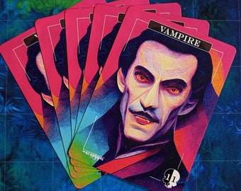 May include: A stack of pink playing cards with a vampire illustration on the top card. The card has the word "Vampire" printed in white letters and a number "11" in a circle with a skull graphic.