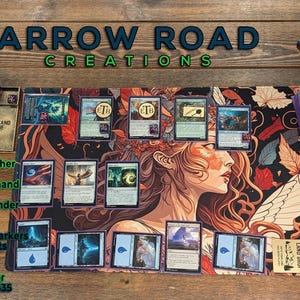 K&ouml;nnte beinhalten: Eine Magic: The Gathering Spielmatte mit einem Fantasy-Kunst-Design mit einem Frauengesicht, umgeben von verschiedenen MTG-Karten, Token und Zubeh&ouml;r. Der Text "ARROW ROAD CREATIONS" wird oben angezeigt.
