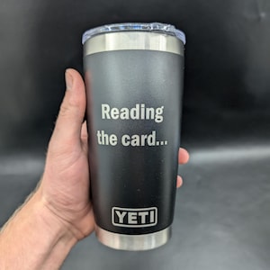 May include: Black Yeti tumbler with a stainless steel lid and a laser engraved message that reads "Reading the card..."