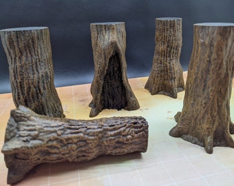 Puede incluir: Cinco miniaturas de tocones de árboles de madera marrón, con un tronco acostado de lado. Los tocones de árboles son todos de diferentes formas y tamaños, y tienen una textura de corteza realista.