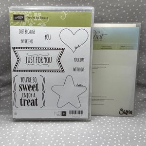 May include: A clear stamp set with the words "You're So Sweet", "Just For You", and other phrases. Includes heart and star shapes, and the word "love". Another package is visible to the right.