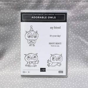 May include: Clear plastic case containing a stamp set titled "ADORABLE OWLS". The set includes four different owl designs with accompanying phrases like "my friend" and "HOOT! HOOT! You're so cute."