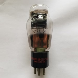 May include: A clear glass vacuum tube with a black base and the text "GENERAL ELECTRIC RADIOTRON" printed on it.