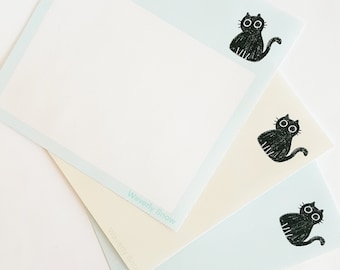 May include: Three light blue notepads with black cat illustrations and the text "Waverly Snow" printed on the bottom right corner of each notepad.