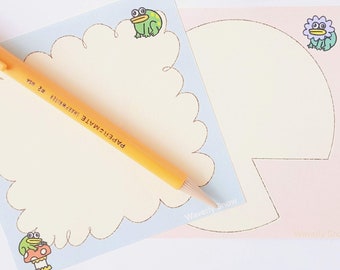 May include: Two pastel-colored notepads with scalloped edges and whimsical illustrations of frogs and flowers. The notepads are blank and ready for writing. The text "Waverly Snow" is printed on the bottom of each notepad.