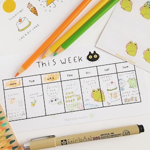 May include: A weekly planner with a black and white grid layout. The days of the week are labeled at the top: Mon, Tue, Wed, Thu, Fri, Sat, Sun. Each day has a space for writing tasks or appointments. The planner is decorated with hand-drawn illustrations of a cat, a plant, a frog, a cake, and a fan. The text "This Week" is written at the top of the planner. The text "Waverly Snow" is written at the bottom of the planner.