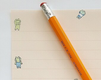 May include: A sheet of lined paper with a yellow pencil and a pattern of green frogs in various poses. The paper has the text "Waverly Snow" at the bottom.