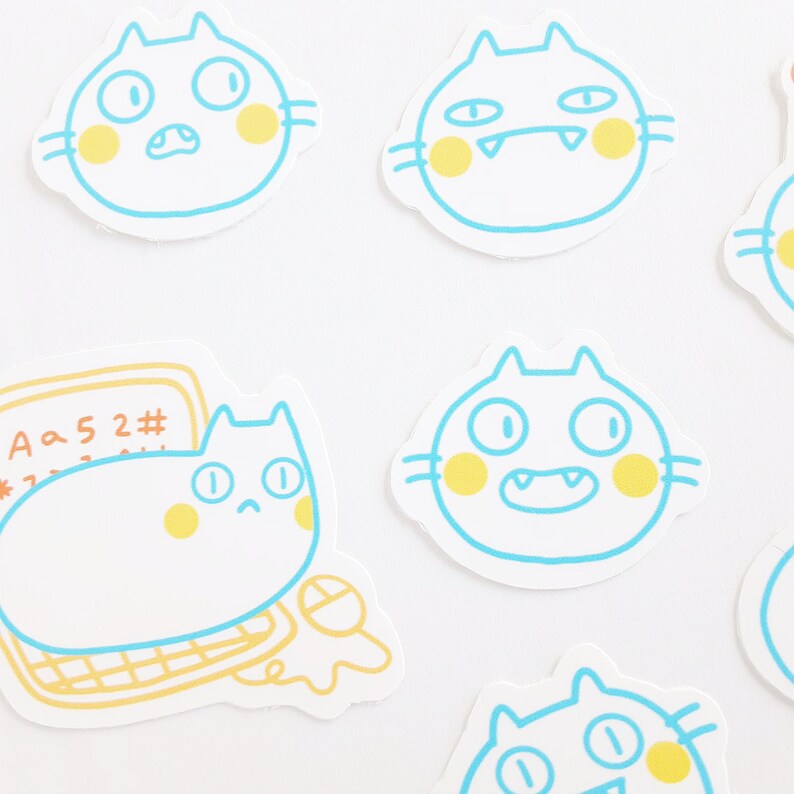 May include: A set of six stickers featuring cartoon cats with different expressions. The cats are outlined in blue and have yellow cheeks. The stickers are on a white background.