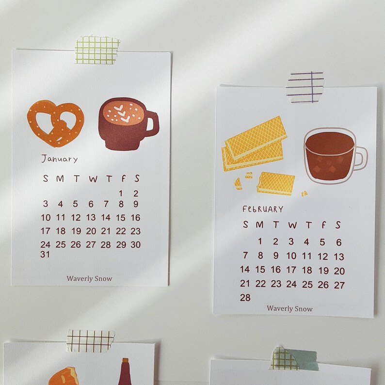 May include: A calendar with illustrations of a pretzel and a cup of hot chocolate for January and waffles and a cup of hot chocolate for February. The calendar is titled "Waverly Snow" and shows the days of the week and the dates for each month.