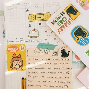 May include: A to-do list with handwritten notes on a yellow sticky note. The notes say "To Do This Week" and "I have to add new things on Etsy. I have to clean and organize my room. I have to mail some orders soon! I'm going to write a lot and have some coffee. I'm going to draw some stickers too!"