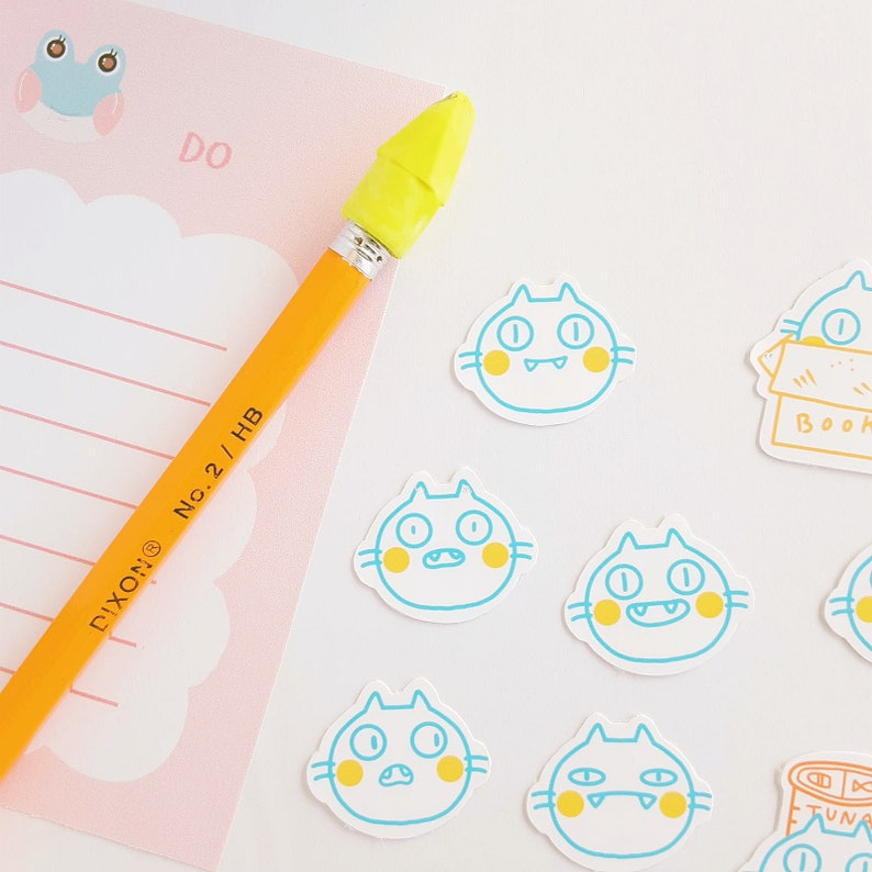 May include: A set of colorful cat stickers with yellow accents. The stickers feature different expressions and are perfect for adding a touch of whimsy to your planner, laptop, or water bottle.
