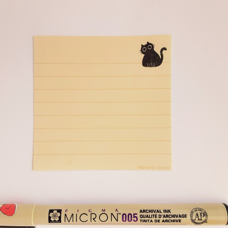 May include: A yellow lined notepad with a black cat illustration and the text "Waverly Snow" at the bottom.