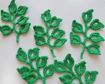 May include: Five individual bright green crochet leaf appliques, each featuring a central stem with multiple small, open-work leaves branching out. The crochet work is detailed with visible yarn stitches, creating a textured, flat botanical design.