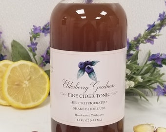 Puede incluir: Una botella de vidrio de tónico de sidra de fuego de saúco Elderberry Goodness. La botella es marrón y tiene una etiqueta blanca con el nombre del producto y las instrucciones de mantener refrigerado y agitar antes de usar. La botella es de 473 ml.
