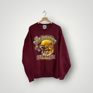 Op de afbeelding: Bordeaux sweatshirt met een afbeelding van een gouden footballhelm en de tekst "1997 National Champions Arizona State". Het is een vintage Lee sweatshirt.